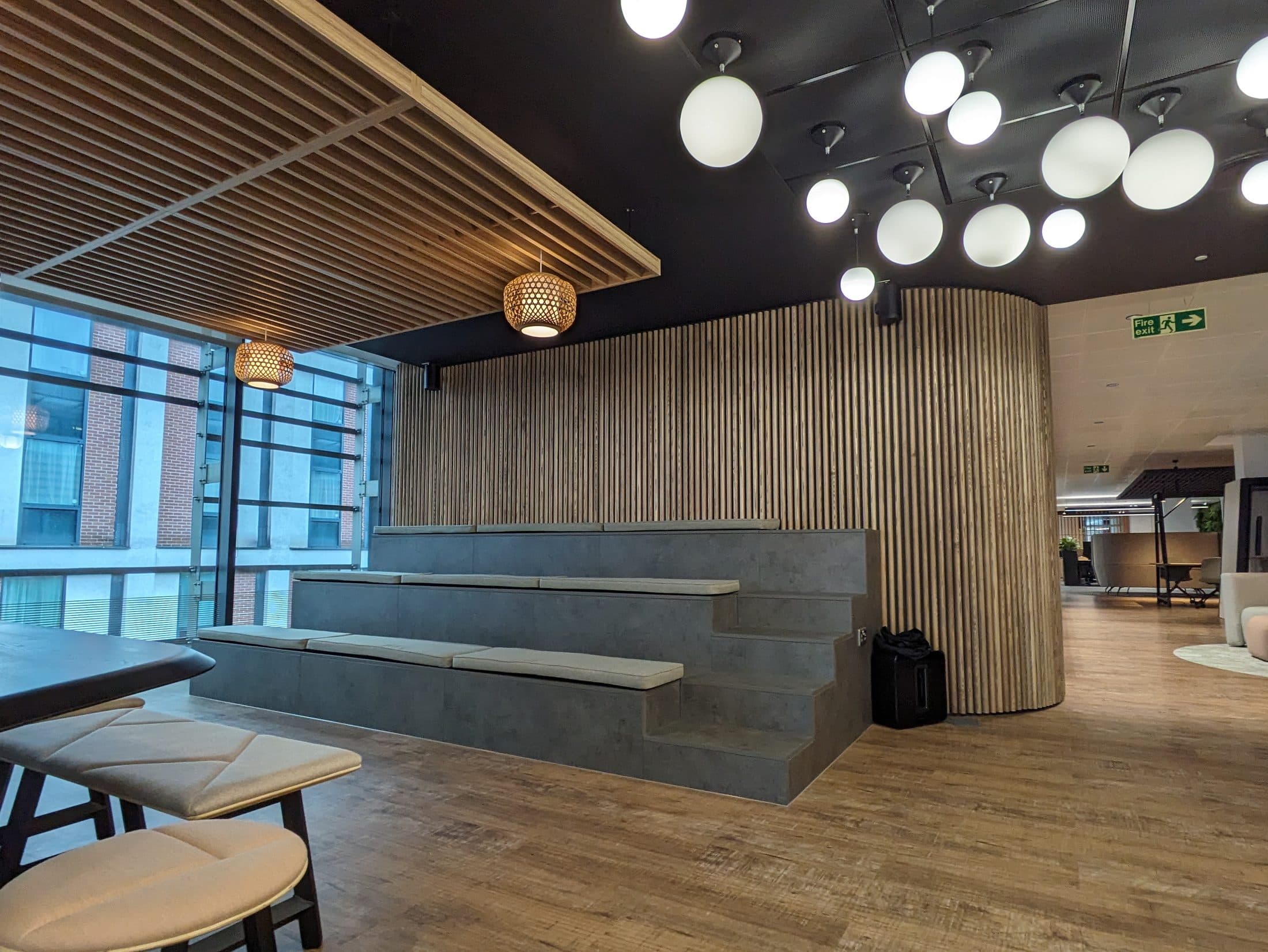 Tiered upholstered seating and a curved slatted timber wall made by Paneltech